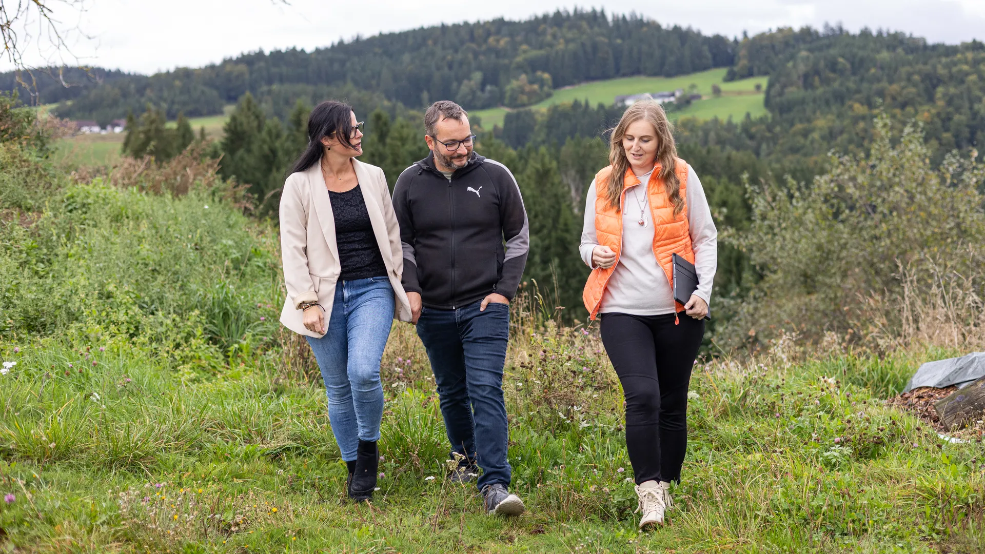 Drei Erwachsene gehen gemeinsam durch eine natürliche Landschaft – passend zu einem Blog über Ausstrahlung, Wirkung auf andere und zwischenmenschliche Dynamik